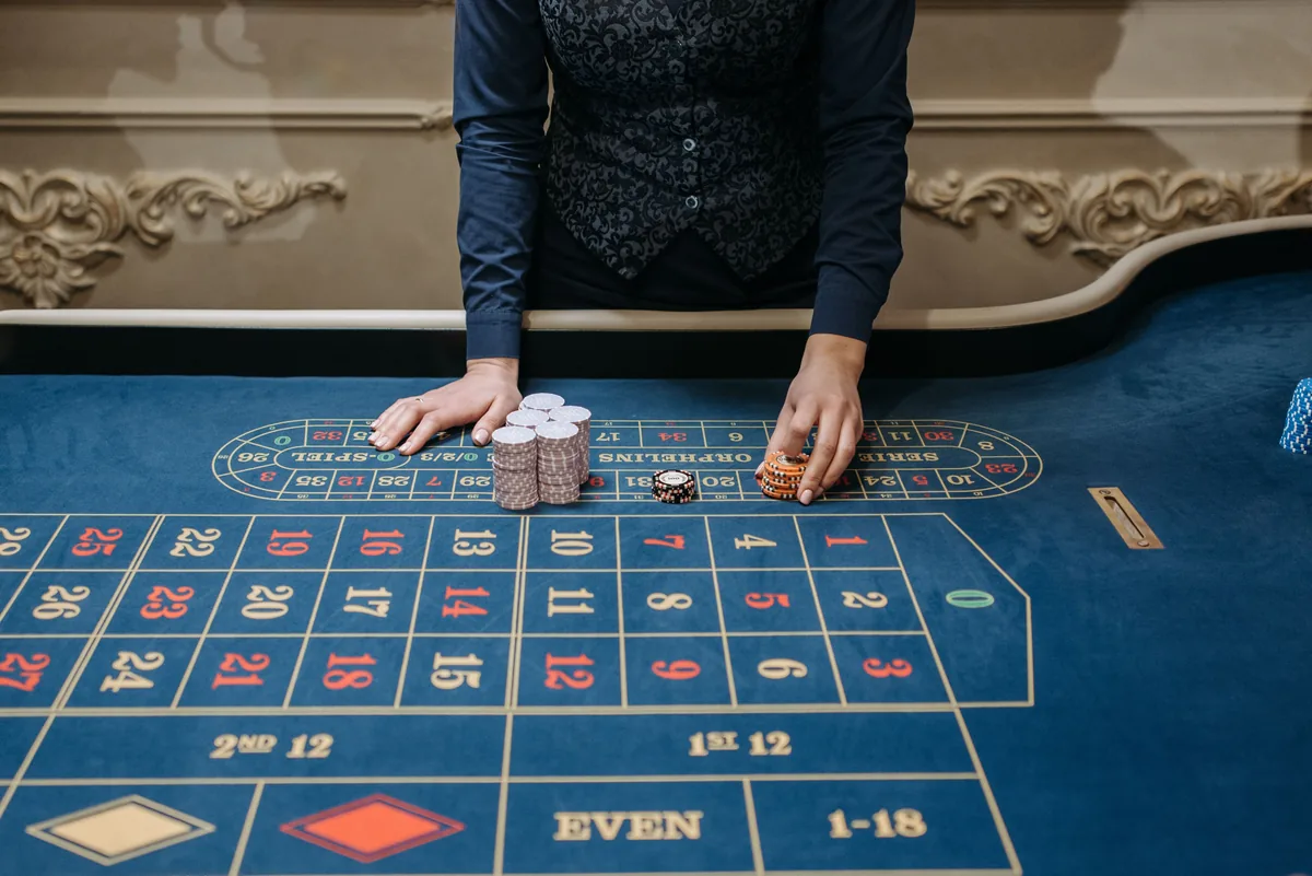 Meja roulette nyata dengan petugas dan keping permainan