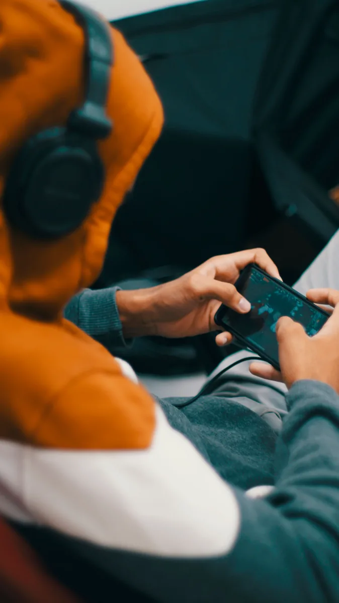 Pemain nyata menggunakan ponsel dan headset untuk bermain game